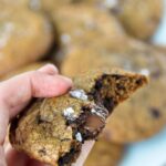 Chocolate chip cookie with a bite showing Nutella