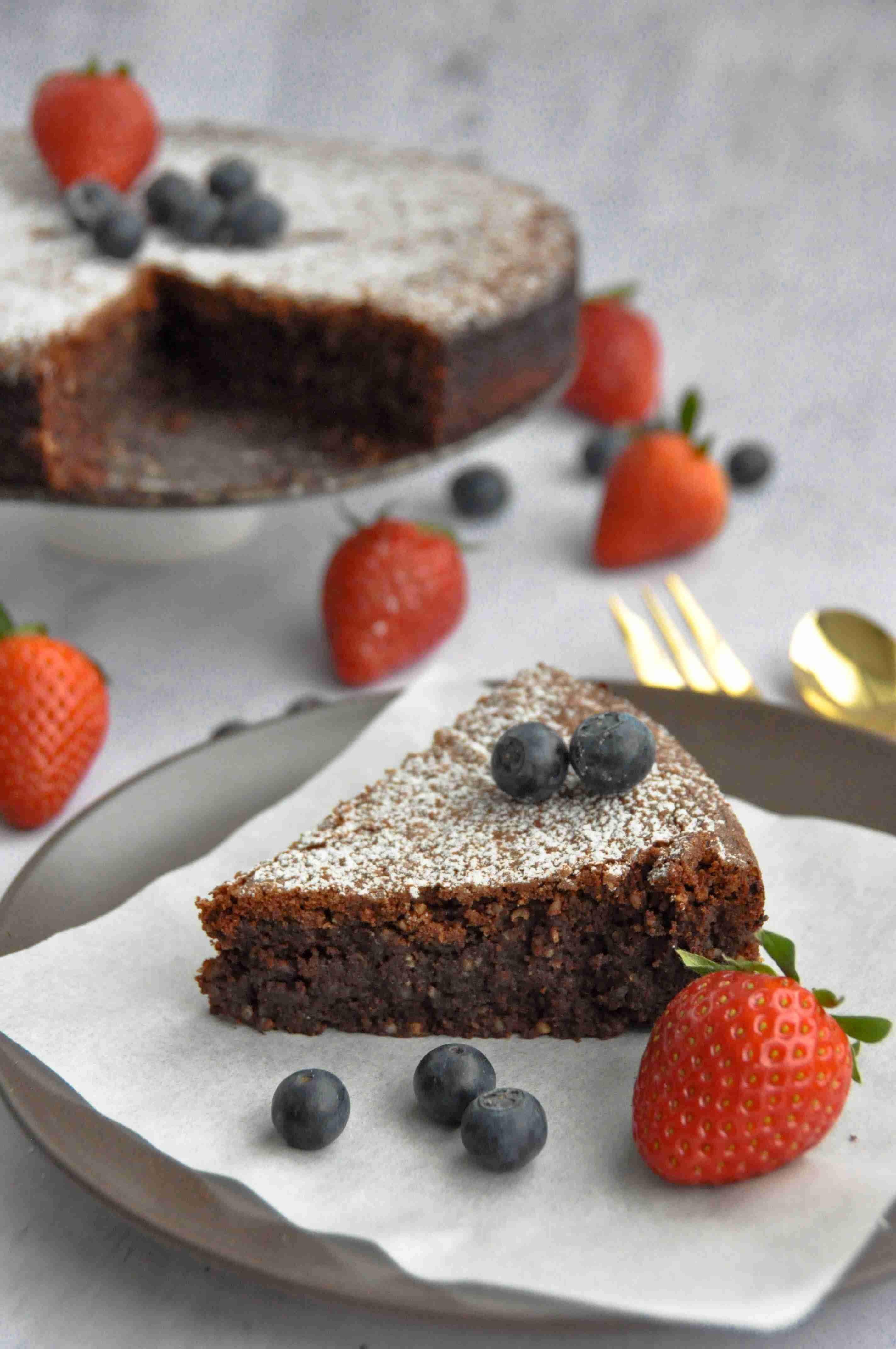 Slice of nutty chocolate cake on a serviette with berries