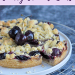 Cherry Crumble Bars on a cooling rack, decorated with fresh cherries