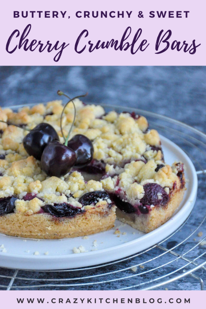 Cherry Crumble Bars on a cooling rack, decorated with fresh cherries