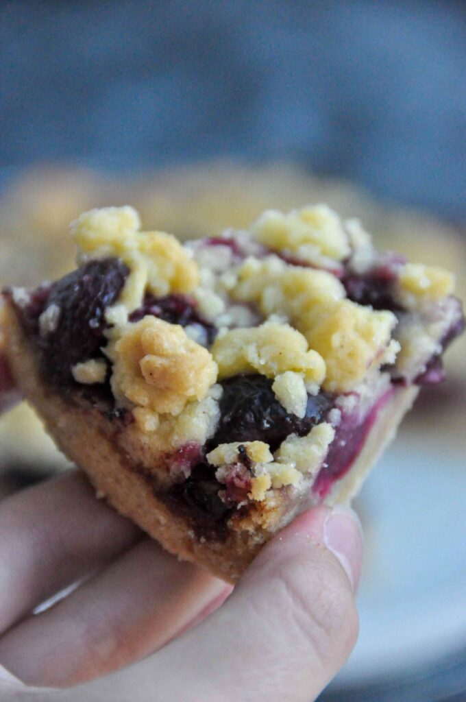 Cherry Crumble Bars on cooling rack and in hand