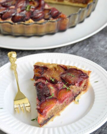 Plum Hazelnut Frangipane Tart, tart in background and slice on plate