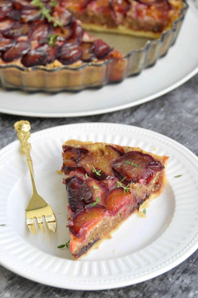 Plum Hazelnut Frangipane Tart, tart in background and slice on plate