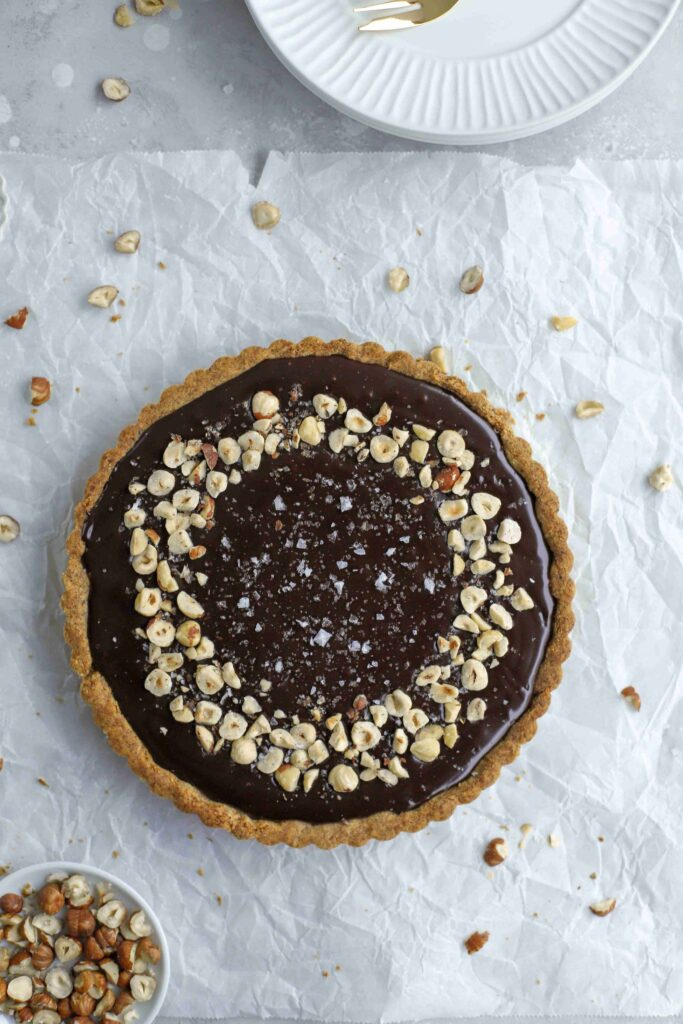 Chocolate Hazelnut Tart with a pile of plates