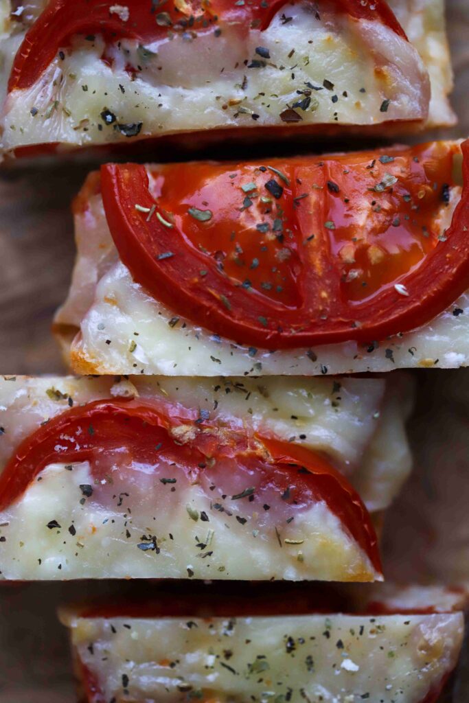 Tomato Mozzarella Baguette on a board cut into pieces