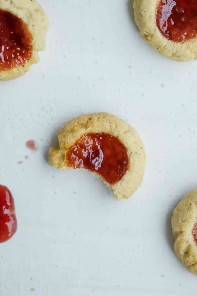 Almond Thumbprint Cookies closeup of the jam and bite missing