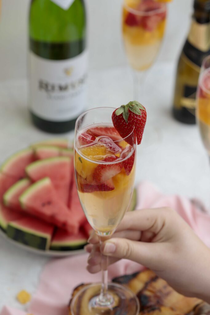 Erdbeer Ananas Bowle im Glas in der Hand