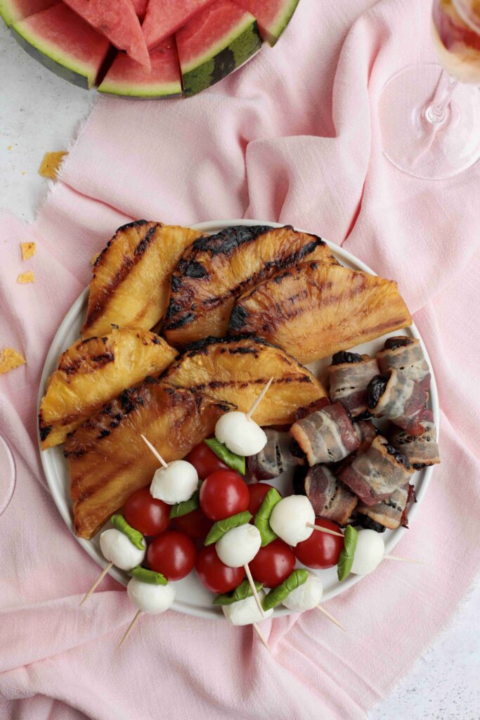 Summer BBQ appetizers: grilled pineapple, caprese sticks and bacon-wrapped prunes